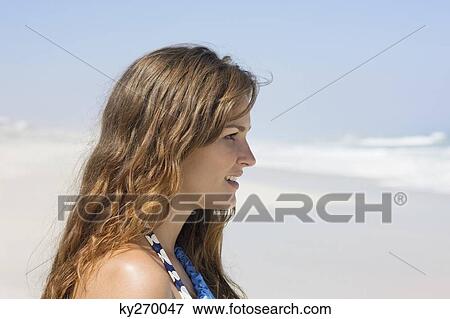 Close-up of a woman on the beach looking at a view View Large Photo Image Stock Photo - Close-up of a woman on the beach looking at a view. Fotosearch