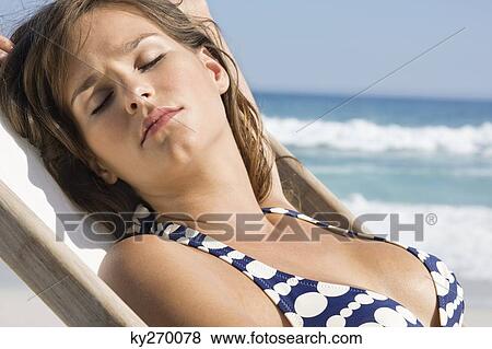 Close-up of a woman resting in a deck chair View Large Photo Image Stock Photo - Close-up of a woman resting in a deck chair. Fotosearch