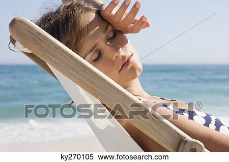 Stock Photography - Close-up of a woman resting in a deck chair. Fotosearch