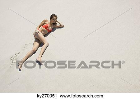 High angle view of a woman lying on the beach View Large Photo Image Stock Image - High angle view of a woman lying on the beach. Fotosearch