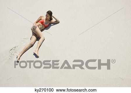 High angle view of a woman lying on the beach View Large Photo Image Stock Image - High angle view of a woman lying on the beach. Fotosearch