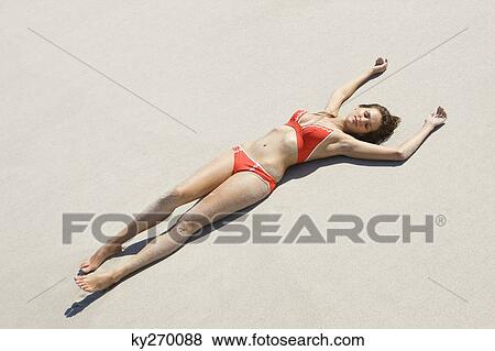 High angle view of a woman lying on the beach View Large Photo Image Stock Photo - High angle view of a woman lying on the beach. Fotosearch