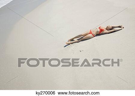 High angle view of a woman lying on the beach View Large Photo Image Stock Photograph - High angle view of a woman lying on the beach. Fotosearch