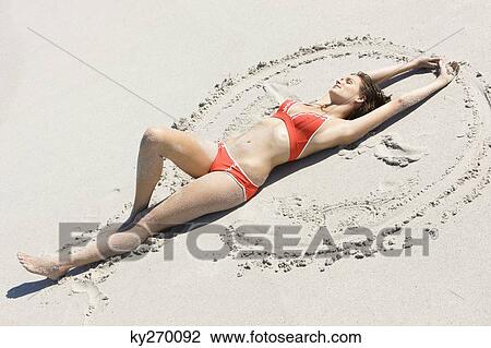 High angle view of a woman making sand angel on the beach View Large Photo Image Stock Image - High angle view of a woman making sand angel on the beach. Fotosearch