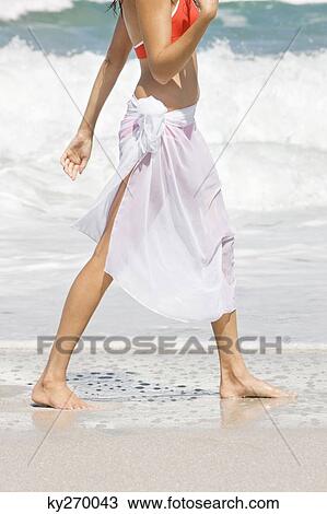 Low section view of a woman walking on the beach View Large Photo Image Stock Image - Low section view of a woman walking on the beach. Fotosearch