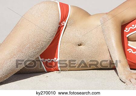 Mid section view of a woman lying on the beach View Large Photo Image Stock Image - Mid section view of a woman lying on the beach. Fotosearch
