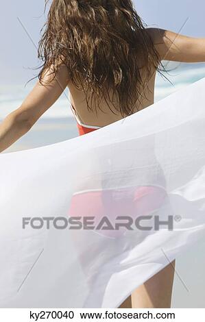 Rear view of a woman walking on the beach View Large Photo Image Stock Image - Rear view of a woman walking on the beach. Fotosearch