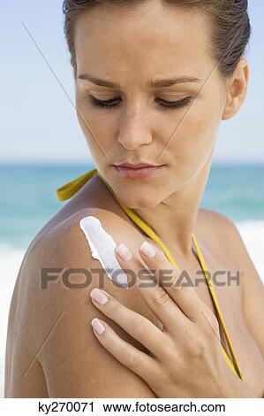 Woman applying suntan lotion on her shoulder View Large Photo Image Stock Image - Woman applying suntan lotion on her shoulder. Fotosearch