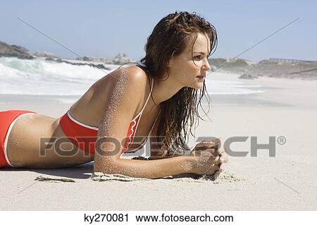 Stock Image - Woman lying on the beach. Fotosearch