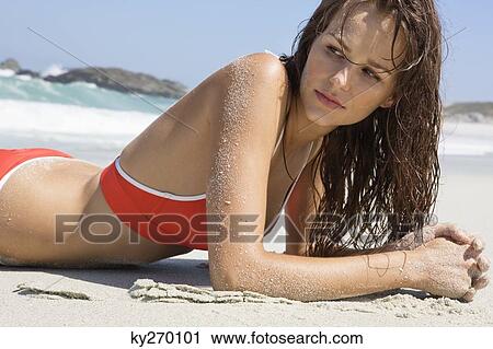 Stock Image - Woman lying on the beach. Fotosearch