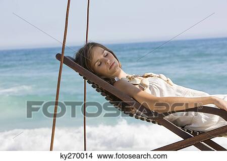 Woman resting in a deck chair View Large Photo Image Picture - Woman resting in a deck chair. Fotosearch