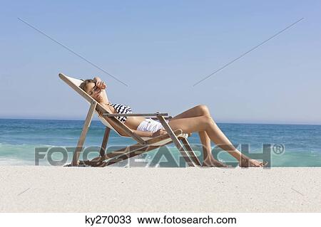 Woman resting in a deck chair View Large Photo Image Stock Image - Woman resting in a deck chair. Fotosearch