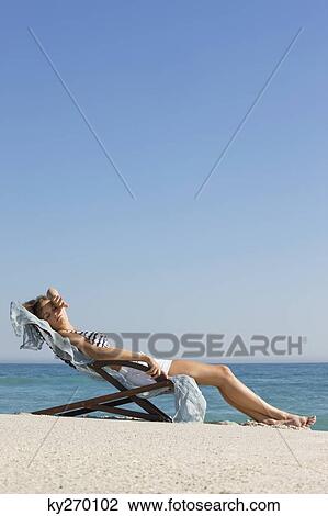 Woman resting in a deck chair View Large Photo Image Stock Image - Woman resting in a deck chair. Fotosearch