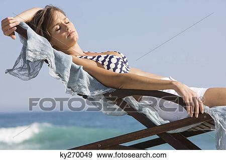 Woman resting in a deck chair View Large Photo Image Stock Photo - Woman resting in a deck chair. Fotosearch
