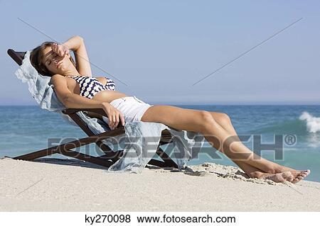 Stock Photo - Woman resting in a deck chair. Fotosearch