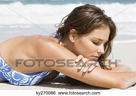Woman sunbathing on the beach View Large Photo Image Stock Photograph - Woman sunbathing on the beach. Fotosearch
