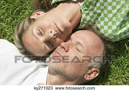 Couple lying in a park View Large Photo Image Stock Image - Couple lying in a park. Fotosearch