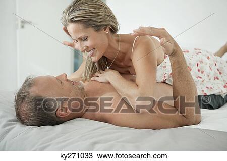 Couple romancing on the bed View Large Photo Image Stock Image - Couple romancing on the bed. Fotosearch
