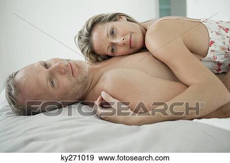 Stock Photo - Couple romancing on the bed. Fotosearch
