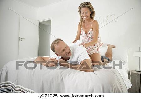 Couple romancing on the bed View Large Photo Image Stock Photography - Couple romancing on the bed. Fotosearch