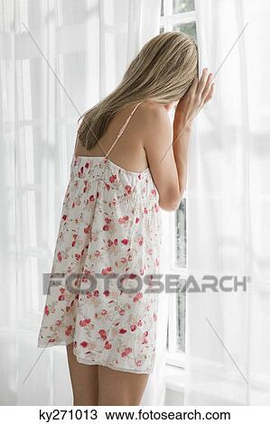 Woman looking through a window View Large Photo Image Stock Image - Woman looking through a window. Fotosearch