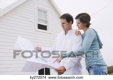 Couple looking at a blueprint of a house View Large Photo Image Picture - Couple looking at a blueprint of a house. Fotosearch