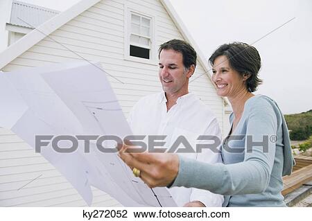 Couple looking at a blueprint of a house View Large Photo Image Stock Image - Couple looking at a blueprint of a house. Fotosearch