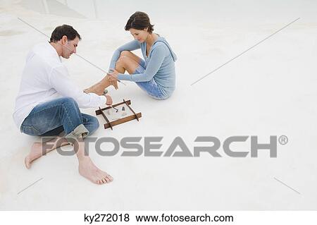 Couple playing with a sandbox View Large Photo Image Stock Photo - Couple playing with a sandbox. Fotosearch
