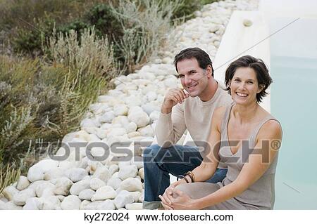 Couple smiling at the poolside View Large Photo Image Picture - Couple smiling at the poolside. Fotosearch