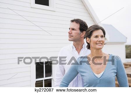 Stock Photo - Couple standing together in front of a house. Fotosearch