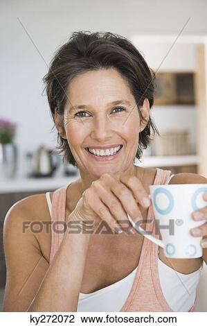 Portrait of a woman holding a cup of coffee View Large Photo Image Stock Image - Portrait of a woman holding a cup of coffee. Fotosearch