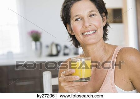 Portrait of a woman holding a glass of juice View Large Photo Image Stock Image - Portrait of a woman holding a glass of juice. Fotosearch