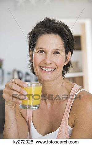Portrait of a woman holding a glass of juice View Large Photo Image Stock Photo - Portrait of a woman holding a glass of juice. Fotosearch