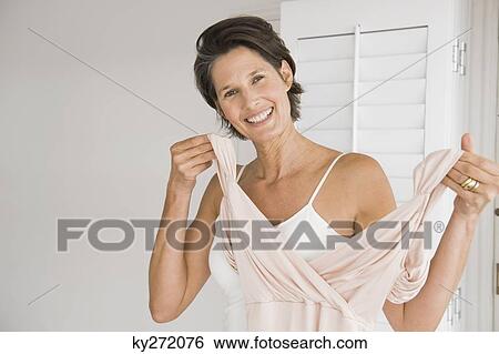 Portrait of a woman trying on a dress View Large Photo Image Stock Photograph - Portrait of a woman trying on a dress. Fotosearch