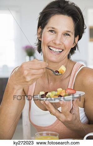 Woman eating fruit salad View Large Photo Image Stock Image - Woman eating fruit salad. Fotosearch
