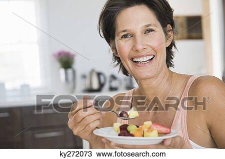 Woman eating fruit salad View Large Photo Image Stock Image - Woman eating fruit salad. Fotosearch