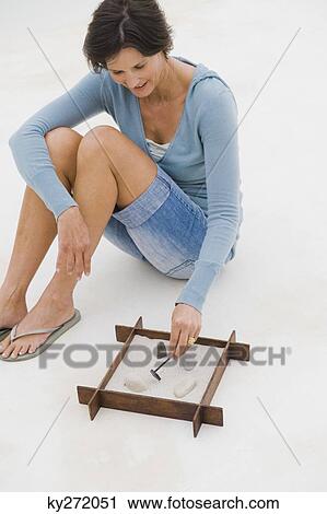 Woman playing with a sandbox View Large Photo Image Stock Image - Woman playing with a sandbox. Fotosearch