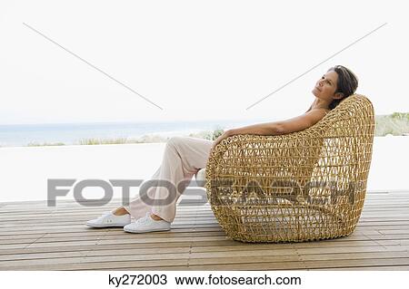 Woman reclining on a chair on the beach View Large Photo Image Stock Image - Woman reclining on a chair on the beach. Fotosearch
