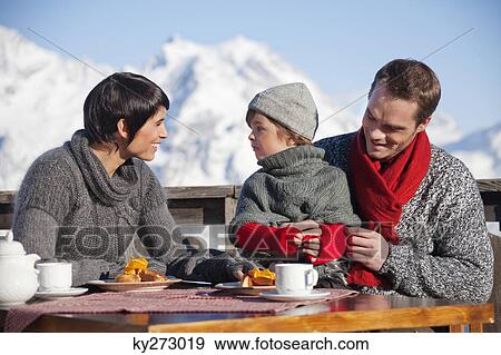 Couple and daughter eating on balcony at ski resort View Large Photo Image Stock Photo - Couple and daughter eating on balcony at ski resort. Fotosearch