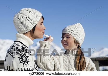 Daughter applying lip balm to her mother View Large Photo Image Stock Photograph - Daughter applying lip balm to her mother. Fotosearch