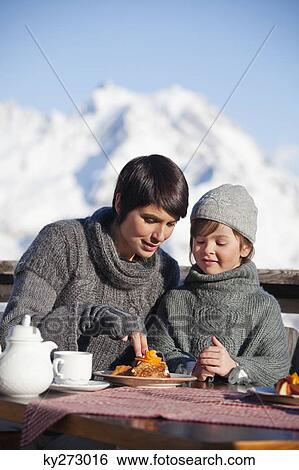 Mother and daughter eating on balcony at ski resort View Large Photo Image Stock Photograph - Mother and daughter eating on balcony at ski resort. Fotosearch