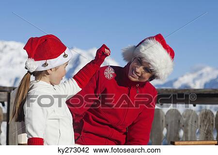 Mother and dauhter wearing Santa hats, playing View Large Photo Image Stock Image - Mother and dauhter wearing Santa hats, playing. Fotosearch