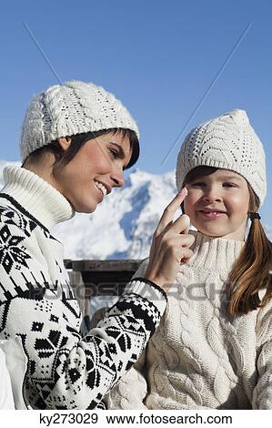 Mother applying moisturizer to daughter's face View Large Photo Image Stock Photo - Mother applying moisturizer to daughter's face. Fotosearch