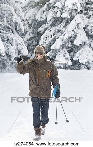 Young man carrying skis on shoulders View Large Photo Image Picture - Young man carrying skis on shoulders. Fotosearch