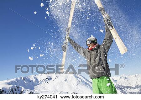 Young man holding his skis above his head View Large Photo Image Stock Image - Young man holding his skis above his head. Fotosearch
