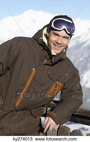 Stock Image - Young man in ski wear smiling at camera. Fotosearch