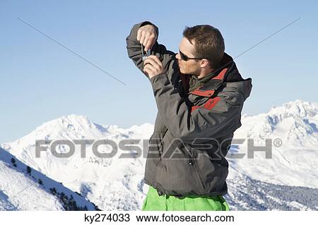 Young man in ski wear taking photos View Large Photo Image Stock Image - Young man in ski wear taking photos. Fotosearch