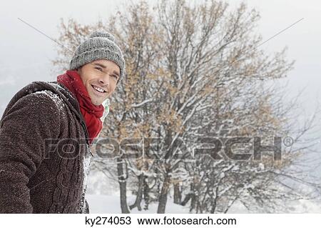 Stock Image - Young man in winter clothes smiling at camera. Fotosearch