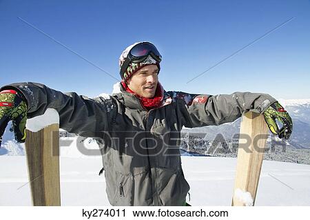 Young man leaning on skis View Large Photo Image Stock Image - Young man leaning on skis. Fotosearch