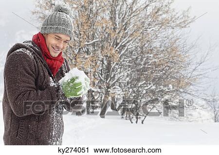 Young man making a snowball View Large Photo Image Stock Image - Young man making a snowball. Fotosearch